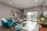 This single-floor residence offers a thoughtfully designed layout that balances functionality and contemporary style. The kitchen serves as a central highlight, showcasing rich dark espresso cabinetry with brushed nickel hardware, granite countertops, a mosaic penny-tile backsplash, and a full suite of stainless steel appliances including an electric range, built-in microwave, dishwasher, and refrigerator. Wood-look flooring runs throughout the main living areas, adding warmth and visual continuity.

The living room is bright and welcoming, benefiting from recessed lighting and a large sliding glass door that opens onto a private balcony, allowing natural light to fill the space and offering outdoor views. Neutral gray walls provide a versatile backdrop throughout the unit.

The bedroom is carpeted for comfort and features multiple windows with ample natural light, a ceiling fan, and direct access to an in-unit laundry area equipped with a stacked washer and dryer. The bathroom is finished with dark cabinetry, granite countertops, a tile accent wall, and wood-look flooring, maintaining the cohesive design aesthetic found throughout the rest of the space.