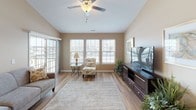 This well-appointed single-floor residence at 4728 Transit Rd in Depew, NY offers a thoughtfully designed layout with a cohesive warm neutral palette throughout. The living room is bright and welcoming, featuring vaulted ceilings, a ceiling fan, and a bank of large windows and a sliding glass door that flood the space with natural light. Light-toned hardwood-style flooring runs through the main living areas, adding warmth and continuity.

The kitchen is outfitted with rich dark espresso cabinetry, granite countertops, and a full suite of stainless steel appliances, including a refrigerator, range, and built-in microwave. Adjacent to the kitchen, the dining area provides a comfortable space for everyday meals.

The primary bedroom is generously sized with plush carpet, vaulted ceilings, a ceiling fan, and a large window. It is accompanied by a bathroom featuring dark cabinetry, granite countertops, and access to a walk-in closet. A secondary bedroom and a dedicated home office — each carpeted and naturally lit — offer flexible living options. An additional full bathroom with matching granite finishes and hardwood-style flooring serves the remaining rooms. The overall design is clean, modern, and move-in ready.