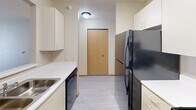 Located at 3175 Pennsylvania Ave in Dubuque, Iowa, this one-bedroom, one-bathroom unit offers a practical and well-organized single-floor layout. The kitchen is efficiently designed with cream-toned cabinetry, white countertops, and black appliances including an electric range, dishwasher, and refrigerator, all set atop light-toned vinyl flooring. A pass-through window connects the kitchen to the adjacent living area, enhancing the sense of openness. The living room features plush carpeting and a sliding glass door that invites natural light and provides access to an outdoor space. The bedroom is a comfortable retreat with soft carpet, a ceiling fan with light fixture, a natural wood-toned double-door closet, and a window overlooking greenery. In total, the unit includes four closets, providing generous storage throughout. The bathroom is clean and functional, featuring a tub-shower combination with a handheld showerhead, a vanity, and easy-care vinyl flooring with accessibility-friendly grab bars. The unit's neutral color palette and consistent finishes throughout create a cohesive, understated ambiance suited for comfortable everyday living.