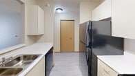Located at 3175 Pennsylvania Ave in Dubuque, Iowa, this one-bedroom, one-bathroom unit offers a practical and well-organized single-floor layout. The kitchen is efficiently designed with cream-toned cabinetry, white countertops, and black appliances including an electric range, dishwasher, and refrigerator, all set atop light-toned vinyl flooring. A pass-through window connects the kitchen to the adjacent living area, enhancing the sense of openness. The living room features plush carpeting and a sliding glass door that invites natural light and provides access to an outdoor space. The bedroom is a comfortable retreat with soft carpet, a ceiling fan with light fixture, a natural wood-toned double-door closet, and a window overlooking greenery. In total, the unit includes four closets, providing generous storage throughout. The bathroom is clean and functional, featuring a tub-shower combination with a handheld showerhead, a vanity, and easy-care vinyl flooring with accessibility-friendly grab bars. The unit's neutral color palette and consistent finishes throughout create a cohesive, understated ambiance suited for comfortable everyday living.