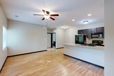Located at 15839 Grand Plaza in Omaha, NE, this one-bedroom, one-bathroom unit offers a well-designed single-floor layout with a thoughtful blend of modern finishes and functional living spaces. The open-concept kitchen and living area serves as the heart of the home, featuring light hardwood-style flooring that runs throughout the main living spaces. The kitchen is equipped with dark espresso cabinetry, granite countertops, a peninsula with a built-in sink, and black appliances including a refrigerator, range, and microwave. Recessed lighting and a ceiling fan provide both illumination and comfort in the living area, which also benefits from multiple windows that invite natural light and outdoor views. The bedroom is a comfortable retreat with plush carpeting, a ceiling fan, and a window overlooking the outdoors. Three closets throughout the unit offer generous storage solutions. The bathroom is finished with tile flooring, a granite-topped dark vanity, a large mirror, and a full tub-shower combination. A dedicated laundry space adds everyday convenience. The unit's neutral color palette and consistent finishes create a clean, cohesive aesthetic throughout.