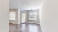 Located at 3770 George Busbee Parkway in Kennesaw, Georgia, this thoughtfully designed one-bedroom, one-bathroom residence offers a clean, modern aesthetic across a single floor. The open-concept kitchen and living area serves as the heart of the home, featuring wood-look flooring, crisp white shaker cabinetry, a quartz peninsula with an undermount sink, stainless steel appliances including a French door refrigerator, electric range, and built-in microwave, plus a tile backsplash and skylight that brightens the space. The living area is bathed in natural light from large windows overlooking a balcony, complemented by crown molding and a ceiling fan. The spacious bedroom is finished with plush carpeting, a ceiling fan, and generous closet access, offering a comfortable retreat. The bathroom showcases large-format, neutral-toned tile surrounding a soaking tub and shower with brushed nickel fixtures. A dedicated laundry room houses a full-sized Whirlpool washer and dryer. Throughout the residence, a neutral color palette, clean lines, and quality finishes create a bright, cohesive ambiance well-suited for modern living.