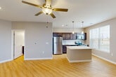 Located at 4005 State Farm Pkwy in Columbia, Missouri, this single-story, one-bedroom, one-bathroom unit offers a thoughtfully designed open-concept layout that maximizes its efficient footprint. Light hardwood-style flooring flows seamlessly throughout the entire space, creating a clean and cohesive aesthetic.

The combined living, dining, and kitchen area forms the heart of the unit. The living and dining space features neutral gray walls, ceiling fans with integrated lighting, and multiple windows that invite an abundance of natural light while framing views of the surrounding landscape. The kitchen is well-equipped with dark espresso cabinetry, a full suite of stainless steel appliances including a refrigerator, electric range, built-in microwave, and dishwasher, along with a large central island topped with a striking white quartz countertop. Pendant lighting above the island adds a polished touch.

The bedroom is a comfortable, well-lit retreat with its own ceiling fan and windows overlooking the outdoors. It includes a dedicated closet with dual shelving and hanging rods, providing ample storage. The bathroom offers a full tub-and-shower combination with a curved curtain rod. Additional utility and laundry spaces round out the practical amenities of this move-in-ready unit.