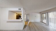 Located at 3209 S IH-35 Service Rd in Austin, TX, this one-bedroom, one-bathroom unit offers a thoughtfully organized single-floor layout that makes efficient use of its space. The living area features light-toned wood-look flooring, neutral white walls, and a textured ceiling. A sliding glass door fills the room with natural light and opens to a private outdoor patio, creating a seamless indoor-outdoor connection. The kitchen is designed in a galley style, featuring gray cabinetry, white countertops, and black appliances including a refrigerator, electric range, and over-the-range microwave. A pass-through window with a breakfast bar connects the kitchen to the living area, enhancing the open feel of the space. A hallway leads from the main living area to the bedroom and bathroom. The bedroom is carpeted for comfort and includes a ceiling fan, natural light from multiple windows with blinds, and a dedicated closet for storage. The bathroom is clean and functional, featuring a full tub-shower combination with white tile surround and chrome fixtures. Throughout the unit, the consistent use of neutral tones and practical finishes contributes to a bright, cohesive, and move-in-ready atmosphere.