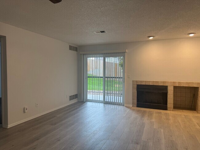 Open Concept living room with wood burning fireplace and wood storage area - 2575 S Syracuse Way