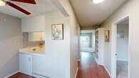 Located at 2635 Milton Ave in Fullerton, CA, this 2-bedroom, 2-bathroom residence offers a well-organized single-floor layout designed for comfortable everyday living. The living room is bright and open, featuring plush carpeting, a textured ceiling, and a sliding glass door that leads to a private balcony, allowing natural light to pour in and offering outdoor views.

The kitchen is efficiently designed in a U-shaped configuration, showcasing white cabinetry, a blue mosaic tile backsplash, white appliances including a refrigerator, range, dishwasher, and microwave, along with warm hardwood-style flooring and ample counter space.

The hallways connect the living spaces smoothly and feature built-in shelving, adding practical storage throughout. Both bedrooms are carpeted and neutrally toned. The primary bedroom is generously sized and includes a ceiling fan and mirrored sliding closet doors, while the second bedroom features a panel door with access to the hallway and its own baseboard heating.

Each of the two bathrooms is clean and functional. One includes a shower stall with a white vanity, and the other features a shower-tub combo with sliding glass doors and a wide vanity with stone-look countertops. Hardwood-style flooring carries through the bathrooms, tying the space together cohesively.