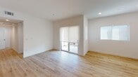 Located in the heart of Los Angeles, this single-floor unit at 1556 Hi Point Street offers a clean, modern aesthetic throughout. Light oak hardwood flooring runs continuously across all rooms, creating a warm and cohesive feel that complements the bright white walls and recessed lighting found throughout the space.

The kitchen is a standout feature, equipped with flat-front light wood cabinetry extending floor to ceiling, sleek white quartz countertops, and stainless steel appliances including a gas range and dishwasher. A matte black faucet adds a contemporary accent, while a striking blue-and-white patterned tile backsplash above the range brings a bold, artistic touch to the space.

The living area is open and airy, with sliding glass doors leading to an outdoor balcony, allowing for abundant natural light and easy indoor-outdoor flow. Additional rooms are bright and versatile, featuring large windows that invite natural light while maintaining a minimalist, move-in ready atmosphere.

Two full bathrooms mirror the home's modern design language, each featuring light wood vanities with white quartz countertops, matte black hardware, framed mirrors, and glass-enclosed shower and tub combinations. The overall ambiance is contemporary and refined, offering a fresh, thoughtfully designed living environment in a prime Los Angeles location.