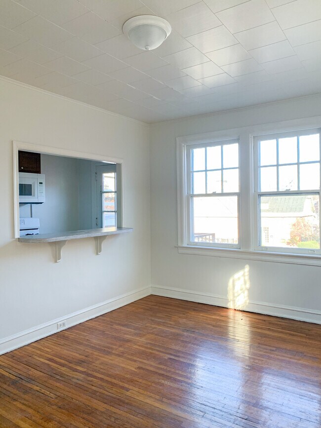 View of dining room looking through to kitchen and out windows to balcony/private parking lot. - 325 N Duke St