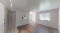 This single-floor residence offers a thoughtfully designed layout that balances comfort and functionality throughout. The open living and dining area greets you upon entry, showcasing warm wood-look laminate flooring, neutral-toned walls, and a textured ceiling that adds a classic touch. A pass-through window connects the living space to the kitchen, enhancing the sense of openness and flow.

The galley-style kitchen is well-equipped, featuring dark espresso cabinetry, granite-look countertops, stainless steel appliances including a refrigerator and microwave, a double-basin sink, and light tile flooring. A window at the end of the kitchen allows natural light to brighten the space.

The bedrooms are generously sized, each finished with plush wall-to-wall carpeting and ceiling fans with integrated lighting for year-round comfort. Windows with blinds provide natural light while maintaining privacy.

Two full bathrooms serve the home, both appointed with dark cabinetry, granite-look vanity tops, and tile flooring. One bathroom features a shower/tub combination, while the other includes an overhead storage cabinet, offering practical storage solutions throughout.

The overall ambiance is clean, neutral, and move-in ready, with consistent finishes that create a cohesive and comfortable living environment.