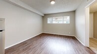 Located at 12603 Eucalyptus Ave in Hawthorne, CA, this efficiently designed one-bedroom, one-bathroom unit makes smart use of its space across a single floor. Wood-look flooring runs throughout the living areas, bedroom, and kitchen, providing a cohesive and easy-to-maintain aesthetic.

The bedroom is generously proportioned relative to the overall footprint, featuring a sliding-door closet for built-in storage and a window that brings in natural light and neighborhood views. A textured popcorn ceiling and neutral warm-beige walls create a clean, understated backdrop.

The kitchen is neatly appointed with white shaker-style cabinetry, a granite-look countertop, a stainless steel sink, a range hood, and a stainless steel refrigerator — offering practical functionality in a compact galley-style layout.

The bathroom is well-equipped, featuring a walk-in shower stall, a toilet, open built-in shelving for storage, and a white vanity with an extended countertop and under-sink cabinetry. A window above the vanity allows natural light to brighten the space. The tiled entryway provides a durable transition point into the unit. Overall, the space presents a clean, move-in-ready environment with consistent finishes throughout.