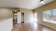 Located at 2080 S Triviz Dr in Las Cruces, NM, this well-designed one-bedroom, one-bathroom unit offers a thoughtful layout across a single floor. Wood-look flooring flows consistently throughout the space, lending warmth and a cohesive aesthetic to every room.

The combined kitchen and living area serves as the heart of the unit. The kitchen is outfitted with dark espresso cabinetry, stone-look countertops, a double-basin sink, and a full suite of stainless steel appliances including a refrigerator, electric range, and microwave. An in-unit washer and dryer area is conveniently accessible from the kitchen, adding practical value to the layout.

The living area benefits from a ceiling fan, elevated ceilings with angled soffits, and a private entry door with a glass panel framed by sheer curtains. A large window allows natural light to fill the space, creating a bright and welcoming atmosphere.

The bedroom is a comfortable, well-proportioned room with its own ceiling fan, a generously sized closet, and a window overlooking the outdoors. Neutral wall tones keep the space feeling open and versatile.

The bathroom features dark cabinetry with a stone-look countertop, a large mirror with overhead lighting, and consistent wood-look flooring, maintaining the unit's modern and cohesive design throughout.