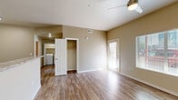 Located at 2080 S Triviz Dr in Las Cruces, NM, this well-designed one-bedroom, one-bathroom unit offers a thoughtful layout across a single floor. Wood-look flooring flows consistently throughout the space, lending warmth and a cohesive aesthetic to every room.

The combined kitchen and living area serves as the heart of the unit. The kitchen is outfitted with dark espresso cabinetry, stone-look countertops, a double-basin sink, and a full suite of stainless steel appliances including a refrigerator, electric range, and microwave. An in-unit washer and dryer area is conveniently accessible from the kitchen, adding practical value to the layout.

The living area benefits from a ceiling fan, elevated ceilings with angled soffits, and a private entry door with a glass panel framed by sheer curtains. A large window allows natural light to fill the space, creating a bright and welcoming atmosphere.

The bedroom is a comfortable, well-proportioned room with its own ceiling fan, a generously sized closet, and a window overlooking the outdoors. Neutral wall tones keep the space feeling open and versatile.

The bathroom features dark cabinetry with a stone-look countertop, a large mirror with overhead lighting, and consistent wood-look flooring, maintaining the unit's modern and cohesive design throughout.