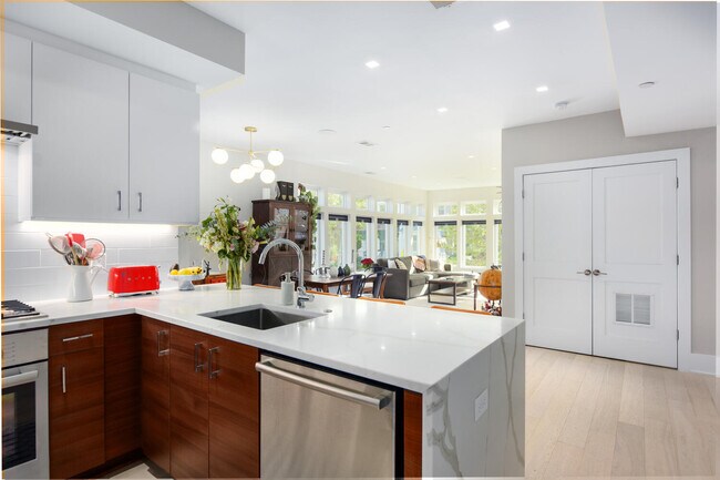 Cocina de concepto abierto con encimeras de cuarzo tipo cascada. - 1001 Monroe St NW