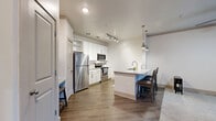 Located at 24 Riverpoint Pl in Rome, Georgia, this 1-bedroom, 2-bathroom single-floor unit offers a thoughtfully designed layout that maximizes functionality and style. The open-concept living area seamlessly connects the kitchen, dining, and living spaces, all finished with warm hardwood-style flooring. The kitchen is a standout feature, outfitted with crisp white cabinetry, subway tile backsplash, granite-style countertops, and a full suite of stainless steel appliances including a refrigerator, electric range, and microwave. A peninsula with pendant lighting provides additional counter space and casual bar seating. The bedroom is a comfortable retreat featuring plush carpeting, a ceiling fan, and a window that allows natural light to filter in. It includes direct access to a walk-in closet with wire shelving for organized storage. The two bathrooms are finished with light wood-look tile flooring, white vanities with granite countertops, and clean white tiling throughout. Additional highlights include a dedicated laundry area, multiple closets for ample storage, and a private patio. The overall aesthetic is modern and neutral, creating a bright and welcoming atmosphere throughout.