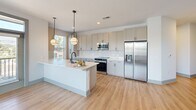 Located at 2500 Pelham Rd in Greenville, SC, this thoughtfully designed 3-bedroom, 2-bathroom single-floor residence offers a bright, contemporary living experience. Light wood-style flooring flows throughout the main living areas, complemented by a neutral, modern color palette and clean architectural lines.

The kitchen serves as a central highlight, featuring a large island with a undermount sink, white quartz countertops, gray shaker-style cabinetry, stainless steel appliances, and stylish globe pendant lighting. The space opens naturally toward the living area, creating an inviting, connected atmosphere ideal for everyday living and entertaining.

Each of the three bedrooms is fitted with plush carpet, ceiling fans, and window blinds that admit ample natural light. The primary bedroom offers notable space and generous closet storage, with wire-rack shelving systems found throughout the six closets. The two bathrooms are finished with white subway tile, gray vanity cabinetry, dark hardware accents, and large framed mirrors.

A built-in mudroom bench with shiplap paneling adds a charming, functional entry nook, while a dedicated laundry area and central hallway contribute to the home's practical layout. A private balcony provides outdoor access with open views. The overall ambiance is clean, fresh, and move-in ready.