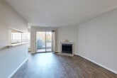 Located at 6609 Reafield Dr in Charlotte, NC, this one-bedroom, one-bathroom residence offers a well-organized, single-level layout with a clean, neutral aesthetic throughout. The combined kitchen and living area serves as the heart of the home. The living room is highlighted by rich hardwood-style flooring, a textured ceiling, and a standout corner fireplace with decorative tile surround. Sliding glass doors flood the space with natural light and open directly onto a private balcony with outdoor views. The galley-style kitchen features white cabinetry, stainless steel appliances including a refrigerator and dishwasher, a gas range, and durable wood-look flooring, maximizing functionality within a compact footprint. A hallway connects the living areas to the private bedroom, which is carpeted and bathed in natural light from two windows. A dedicated closet provides ample storage. The full bathroom includes a single-sink vanity with white cabinetry, a toilet, and a tub-shower combination. A separate laundry room accommodates a full-size washer and dryer with overhead shelving for added convenience. Neutral wall tones and consistent finishes create a cohesive and move-in-ready atmosphere throughout the home.