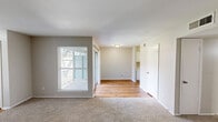 Located at 335 E San Augustine St in Deer Park, Texas, this single-story, 3-bedroom, 2-bathroom home offers a practical and comfortable layout. The living room is a generously sized, carpeted space bathed in natural light from large windows, with a hallway connecting seamlessly to the rest of the home. The galley-style kitchen is a functional highlight, featuring white cabinetry with brushed nickel hardware, light granite-look countertops, a stainless steel sink, and warm hardwood flooring that runs the length of the space — providing a bright and clean workspace. Each of the three bedrooms is finished with neutral-toned carpet and ceiling fans with integrated lighting, creating a comfortable environment. The primary bedroom is notably spacious and includes a double-door closet. The two additional bedrooms are well-proportioned with windows that bring in natural light. Both bathrooms are equipped with tub-shower combinations featuring white subway tile surrounds and chrome fixtures, maintaining a clean, consistent aesthetic throughout. Neutral wall colors and white trim are used consistently across the home, lending a cohesive and move-in ready feel to the entire floor plan.