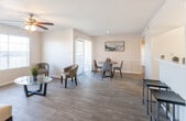 Located at 535 S Mesa Hills Dr in El Paso, TX, this single-floor unit offers a thoughtfully laid-out living space with a warm, functional design throughout. The open-concept living and dining area is bathed in natural light from large windows and a sliding glass door fitted with vertical blinds, which leads to an outdoor area. Light wood-look flooring runs through the main living spaces, complemented by ceiling fans and textured ceilings. The living area provides a comfortable, airy feel with ample room for seating arrangements, while the adjacent dining space features a chair rail accent wall and sliding door access.

The kitchen is outfitted with slate-blue cabinetry, a white subway tile backsplash, black appliances including an electric range and refrigerator, and a window that brings in natural light. The two bedrooms feature plush carpeting, ceiling fans with light fixtures, and windows with blinds, offering a quiet and comfortable retreat.

Both bathrooms echo the kitchen's design aesthetic with blue-toned vanities, white countertops, large mirrors, and wood-look flooring. Each bathroom includes a tub/shower combination. The overall palette of neutral tones and consistent finishes throughout the space creates a cohesive and inviting atmosphere.