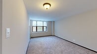 Situated at 1380 E Hyde Park Blvd in Chicago's historic Hyde Park neighborhood, this single-floor unit features a practical and comfortable layout spread across several well-defined rooms. The living areas are finished with plush wall-to-wall carpeting and neutral-toned walls, creating a clean, understated aesthetic throughout. Multiple windows allow natural light to filter in, offering pleasant outdoor views of the surrounding greenery.

The bedrooms are generously proportioned, each featuring carpeted floors, ample wall space, and access to closet storage. The rooms connect via a central hallway, lending a cohesive flow to the floor plan. One bedroom includes a bifold closet door leading to additional storage space.

The kitchen is equipped with white cabinetry, granite-style countertops, tile flooring, and a full suite of white appliances including a refrigerator, electric range, over-the-range microwave, and ample cabinet storage above and below the counter.

Two full bathrooms serve the unit, each featuring a white vanity with under-sink storage, a large mirror, and a tub/shower combination. One bathroom includes a stylish three-bulb vanity light fixture and tile flooring, while the second offers a similarly clean and functional design. Both bathrooms maintain a bright, orderly appearance consistent with the rest of the unit.