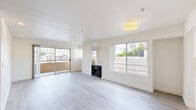 Located at 6619 Leland Way in the heart of Los Angeles, CA 90028, this 2-bedroom, 2-bathroom residence offers a well-designed single-floor layout with modern finishes throughout. The bright and airy living room serves as the centerpiece of the home, featuring light gray wood-style flooring, a wood-burning fireplace accented by a full-length wall mirror above, and large sliding glass doors that open to a private balcony with city views. Multiple windows flood the space with natural light, creating an inviting, open atmosphere. The galley-style kitchen is thoughtfully appointed with crisp white cabinetry, quartz countertops, stainless steel appliances including a gas range and built-in microwave, and a deep undermount sink beneath a window overlooking the outdoors. Both bathrooms are elegantly finished with marble-style tile surrounds in the tub-shower combinations, white vanities with quartz countertops, and wood-look tile flooring. The generously sized primary bedroom features plush carpeting, a sliding glass door leading to a balcony, and mirrored sliding closet doors that enhance the sense of space. The second bedroom also features carpeted flooring and mirrored closet doors. Two hallways provide seamless connectivity throughout the home, completing a functional and stylish layout.