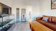 This 470 square foot apartment in Goleta, California, offers a well-designed living space with one bedroom and one bathroom. The interior showcases a modern and bright aesthetic, with light-colored walls and ample natural light throughout. The living room features a comfortable leather sofa, a wooden coffee table, and a large window offering views of the surrounding area. A beach-themed artwork adorns the wall, adding a coastal touch to the space.

The bedroom, measuring 150 square feet, is furnished with a single bed adorned with a polka-dot comforter. A small side table and decorative wall hangings complete the room's cozy ambiance. The bathroom is efficiently designed with a white vanity, modern fixtures, and a clean, minimalist look.

The kitchen boasts light blue cabinetry, stainless steel appliances, and white countertops, creating a fresh and inviting cooking space. The apartment's layout maximizes the use of space, with a hallway connecting the various rooms. Flooring throughout the apartment appears to be a light-colored laminate, contributing to the overall bright and airy feel.

Additional features include a full-length mirror in the living area, built-in closet space, and a vanity area in the bedroom. The apartment's design prioritizes functionality while maintaining a stylish and contemporary appearance, making it an ideal living space for individuals or couples seeking a compact yet comfortable home in Goleta.
