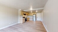 Located at 1691 N Oracle Rd in Tucson, Arizona, this 1-bedroom, 1-bathroom unit offers a thoughtfully designed layout across a single floor. Light wood-style flooring flows consistently throughout, creating a clean and cohesive aesthetic. The combined kitchen and living area serves as the heart of the unit, with the living space offering a welcoming window that invites natural light and outdoor views of the surrounding Tucson landscape. A wall-mounted HVAC unit provides convenient climate control. The kitchen is well-equipped with light wood cabinetry, stainless steel appliances including a refrigerator, range, and built-in microwave, as well as ample counter space and a single-basin sink — ideal for everyday cooking. Crown molding accents the living area, adding a subtle touch of character. The spacious primary bedroom provides generous room for furnishings and connects to a hallway leading to the full bathroom. The bathroom features a light wood vanity with a white countertop, black hardware accents, and matching light flooring, maintaining the unit's modern and neutral design language throughout. Overall, the space presents a clean, updated interior with a bright and airy ambiance.