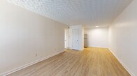 Located at 1366 Sheridan Dr in Lancaster, Ohio, this 2-bedroom, 1-bathroom unit offers a practical and comfortable single-floor layout. The combined kitchen and living area provides an open, functional flow, with the kitchen standing out for its stainless steel appliances — including a refrigerator, gas range, and over-the-range microwave — complemented by white cabinetry and light granite-look countertops. Light wood-look vinyl flooring runs throughout the main living areas, contributing to a bright and cohesive aesthetic.

The living room is open and airy, featuring a patterned textured ceiling and neutral walls that create a clean, move-in-ready atmosphere. The primary bedroom is generously proportioned and includes a sliding-door closet with a full-width rod for ample storage, while both bedrooms are finished with plush gray carpeting and natural light from windows. The full bathroom is neatly appointed with a white vanity, large mirror, and a tub-shower combo with built-in shelving.

Throughout the unit, the consistent use of light tones, updated flooring, and clean finishes gives the space a fresh, modern feel well-suited for comfortable everyday living in Lancaster, OH.