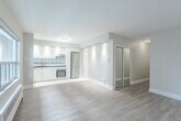 This 340 square foot apartment, located at 87 Jameson Ave in Toronto, offers a thoughtfully designed living space. The main area features an open-concept layout with large windows that flood the room with natural light and provide urban views. Light-toned wooden flooring extends throughout, creating a sense of warmth and continuity.

The living area is versatile, with ample space for both seating and sleeping arrangements. A sliding glass door leads to a private balcony, extending the living space outdoors. The kitchen, while not visible in the images, is likely integrated into the main living area.

The bathroom is modern and efficiently designed. It features a white bathtub with shower, complemented by white tiled walls with a striking black tile accent. A white vanity with a dark countertop provides storage, and the floor is finished with a patterned tile.

Storage solutions are evident, with built-in closets visible in the main living area. Recessed lighting in the ceiling adds to the contemporary feel of the space. A wall-mounted heating unit beneath the window ensures comfort year-round.

Despite its compact size, this apartment maximizes space usage, offering a functional and stylish urban living solution in the heart of Toronto.