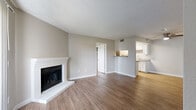 Located at 2961 W Centennial Dr in Littleton, Colorado, this single-level, two-bedroom, two-bathroom home offers a well-organized layout across a comfortable footprint. The living room serves as the heart of the space, featuring warm wood-look flooring, a textured ceiling, and a classic white brick fireplace that adds character and a cozy focal point. A sliding glass door with vertical blinds brings in natural light and provides outdoor access. The kitchen is designed as a galley-style space with ample white shaker cabinetry, granite-look countertops, stainless steel appliances including an electric range and refrigerator, a dishwasher, and a skylight overhead that brightens the workspace. A pass-through counter connects the kitchen to the adjacent dining area, enhancing the open feel. The primary bedroom is generously sized, complete with a closet and easy access to a full bathroom. The second bedroom features a window with natural views and its own closet. Both bathrooms include tub-shower combinations and wood-look flooring for a cohesive aesthetic. Additional conveniences include a dedicated laundry area, a utility room, and three closets throughout for ample storage. The neutral color palette and consistent flooring tie each room together seamlessly.