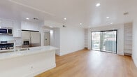 Located at 1806 N Berendo St in the desirable Los Feliz neighborhood of Los Angeles, this single-floor unit offers a clean, modern aesthetic throughout. The open-concept living and dining area is anchored by warm light wood flooring, recessed lighting, and a large sliding glass door that fills the space with natural light and provides access to an outdoor area. Built-in shelving adds both function and character to the living room.

The kitchen is thoughtfully designed with white cabinetry extending to the ceiling, a marble-look countertop with a breakfast bar overhang, and a full suite of stainless steel appliances including a gas range, microwave, dishwasher, and a large French door refrigerator. An in-unit stacked washer and dryer is conveniently integrated into the kitchen area.

Two well-proportioned bedrooms each feature the same light wood flooring, ceiling fans, and windows with views of surrounding greenery, ensuring comfortable airflow and natural light.

The bathroom maintains the unit's crisp, modern palette with white subway tile surrounding the bathtub and shower, a built-in niche, light wood flooring, and a contemporary floating vanity. The overall design is cohesive and bright, presenting a move-in-ready space in a prime Los Angeles location.