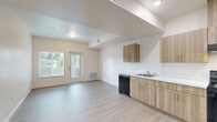 Located at 771 Harrington Way in Folsom, California, this two-bedroom, one-bathroom residence offers a thoughtfully designed single-level layout with a clean, contemporary aesthetic throughout. Light wood-style flooring flows seamlessly across all rooms, complemented by crisp white walls and white panel doors that create a bright, cohesive feel.

The kitchen is a standout feature, showcasing an L-shaped layout with warm wood-toned cabinetry on both upper and lower levels, white countertops, a built-in range hood, and a full suite of black appliances including a refrigerator, electric range, and dishwasher. Recessed lighting illuminates the space effectively.

Both bedrooms are well-proportioned and share a consistent, neutral design with light flooring and window blinds that frame views of surrounding greenery. The primary bedroom offers a generous footprint and convenient access to a dedicated walk-in closet outfitted with wire shelving and hanging rods for ample storage.

The bathroom is clean and functional, featuring a full tub-shower combo with built-in shelving, a curved shower rod, and easy-care surfaces. The overall layout makes efficient use of the available square footage, providing comfortable living across every room.