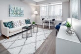 Located at 151 Beecroft Road in the Willowdale neighbourhood of North York, Toronto, this single-floor unit offers a thoughtfully designed layout that maximizes both functionality and comfort. The open-concept living and dining area serves as the heart of the space, featuring light wood-tone flooring, neutral grey walls, and large windows that invite generous natural light and offer views of the surrounding cityscape. A dedicated dining nook sits adjacent to the living area, creating a seamless flow for everyday living and entertaining.

The kitchen is efficiently laid out with white cabinetry, a light countertop, stainless steel appliances including a refrigerator, stove, and dishwasher, and track lighting overhead. A peninsula counter separates the kitchen from the living area, enhancing the open feel of the space.

The unit includes multiple bedrooms, each featuring light hardwood-style flooring, neutral tones, and ample closet space with sliding or hinged doors. One bedroom benefits from a sliding glass door with city views, while another includes a built-in desk area, ideal as a workspace. The bathroom is finished with tile flooring, a white vanity with an integrated sink, and a full bathtub with shower.