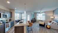 Located in Humble, TX, this single-story residence offers a thoughtfully designed open-concept layout with contemporary finishes throughout. The kitchen serves as a central highlight, featuring dark wood cabinetry, granite countertops, stainless steel appliances including a French door refrigerator, electric range, and built-in microwave. A spacious island with an undermount sink and seating for two is illuminated by modern pendant lighting, connecting seamlessly to the dining and living areas. Light wood-style flooring flows throughout the main living spaces, enhancing the bright, airy atmosphere created by multiple windows dressed with blinds and sheer curtains. The dining nook benefits from a corner window arrangement, flooding the space with natural light. The living room features a ceiling fan and a neutral color palette, making it a versatile and comfortable gathering space. Each bedroom is well-proportioned, with windows offering outdoor views and ceiling fans for comfort. The bathrooms are finished with granite-topped dark cabinetry, dual-sink vanities, and tub-shower combinations. A walk-in closet is accessible from the primary bathroom, adding practical storage. Overall, the unit presents a clean, modern aesthetic with quality finishes.