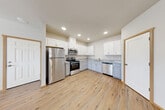 Located at 15037 Tahoma Blvd SE in Yelm, Washington, this single-story, three-bedroom, two-bathroom home offers a thoughtfully organized layout with modern finishes throughout. Warm-toned, wood-look luxury vinyl plank flooring and crisp white walls flow consistently through every room, creating a clean, cohesive aesthetic.

The kitchen is a functional highlight, featuring white upper cabinetry, gray lower cabinets, granite-look countertops, and a full suite of stainless steel appliances including a refrigerator, gas range, microwave, and dishwasher. Recessed lighting illuminates the space effectively. The kitchen connects conveniently to the open living area, which provides a comfortable, flexible layout.

A central hallway connects the three bedrooms, each finished with the same durable flooring and warm wood trim. The spacious primary bedroom offers generous room and its own closet. Additional bedrooms are served by a second closet. The bathrooms are clean and practical, with one featuring a sliding-glass enclosed shower stall and granite-accented vanity.

A dedicated laundry room houses a full-size top-load washer and dryer. A wall-mounted ductless mini-split unit provides efficient heating and cooling. Throughout the home, warm wood door and window trim accents add a welcoming touch to the bright, move-in-ready interior.