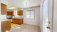 Located at 1008 Emery Rd in Lawrence, Kansas, this single-floor, 2-bedroom residence offers a straightforward and functional layout designed for comfortable everyday living. The space is finished throughout with neutral-toned carpet, white walls, and gold-accented hardware, creating a clean and cohesive aesthetic.

The kitchen is equipped with warm oak cabinetry offering ample storage, light-colored countertops, a double sink, a white electric range, a full-size refrigerator, and a dishwasher. A patterned tile floor distinguishes the kitchen area, and a multi-bulb ceiling light fixture provides task lighting. A window with blinds allows natural light to fill the adjacent dining area, which is also served by a sliding glass door for additional brightness.

The spacious primary bedroom is a standout feature of the home, accommodating generous furniture arrangements with ease. It is fitted with a ceiling fan with light kit and two windows dressed with blinds, ensuring good ventilation and natural light. The second bedroom is carpeted and includes a built-in closet with shelving, a window, and access to the hallway. A connecting hallway links the bedrooms and living areas, providing smooth circulation throughout the residence. The overall ambiance is bright, neutral, and move-in ready.