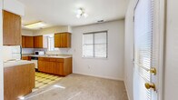 Located at 1008 Emery Rd in Lawrence, Kansas, this single-floor, 2-bedroom residence offers a straightforward and functional layout designed for comfortable everyday living. The space is finished throughout with neutral-toned carpet, white walls, and gold-accented hardware, creating a clean and cohesive aesthetic.

The kitchen is equipped with warm oak cabinetry offering ample storage, light-colored countertops, a double sink, a white electric range, a full-size refrigerator, and a dishwasher. A patterned tile floor distinguishes the kitchen area, and a multi-bulb ceiling light fixture provides task lighting. A window with blinds allows natural light to fill the adjacent dining area, which is also served by a sliding glass door for additional brightness.

The spacious primary bedroom is a standout feature of the home, accommodating generous furniture arrangements with ease. It is fitted with a ceiling fan with light kit and two windows dressed with blinds, ensuring good ventilation and natural light. The second bedroom is carpeted and includes a built-in closet with shelving, a window, and access to the hallway. A connecting hallway links the bedrooms and living areas, providing smooth circulation throughout the residence. The overall ambiance is bright, neutral, and move-in ready.