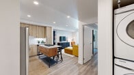 Located at 37 8th Ave in Oakland, CA, this thoughtfully designed single-floor residence offers a clean, contemporary aesthetic with an efficient and functional layout. Light wood-look flooring runs throughout, tying together the open-concept living and kitchen area that serves as the heart of the home. The kitchen is outfitted with light wood cabinetry extending to the ceiling, stainless steel appliances including a gas range and French door refrigerator, a white subway tile backsplash, and a waterfall-edge kitchen island with bar seating — ideal for casual dining and entertaining. The living area flows seamlessly from the kitchen and is filled with natural light from large sliding glass doors that open onto a private outdoor balcony, perfect for relaxing or enjoying the surrounding views. The bedroom is generously proportioned, featuring recessed lighting, wall-mounted sconce lighting, and direct access to a spacious walk-in closet with ample shelving and hanging rods. The bathroom is crisp and modern, with a wood-toned vanity, integrated sink, LED-lit mirror, and light, airy finishes. A smart lock entry, ceiling ventilation, and recessed lighting throughout complete this well-equipped urban residence.