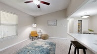 This single-story residence offers a thoughtfully designed layout across two bedrooms and two bathrooms. The living room features plush wall-to-wall carpeting, a ceiling fan, and an open sightline into the kitchen, creating a cohesive and functional common area. The kitchen is appointed with white shaker-style cabinetry, marble-look countertops, light wood-style vinyl flooring, stainless steel appliances including a dishwasher, microwave, and range, as well as a double sink — all arranged in an efficient galley-style configuration.

The bedrooms are carpeted and finished in the same neutral warm-gray palette that carries throughout the unit. Each room features a ceiling fan, natural light from blinds-fitted windows, and easy access to a bathroom. The primary bedroom is a comfortably sized retreat with an adjoining bathroom area. Both bathrooms include a tub-shower combination, white vanity cabinetry, marble-look countertops, large mirrors with vanity lighting, and wood-look tile flooring. A dedicated closet provides additional storage. The overall aesthetic is clean, neutral, and move-in ready.