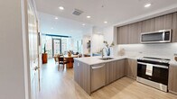 Located in Dallas's vibrant Uptown neighborhood, Unit 1409 at 2660 Enid St is a thoughtfully designed one-bedroom, one-bathroom residence offering a refined urban living experience. The open-concept layout seamlessly connects the living, dining, and kitchen areas, all finished with light hardwood flooring that lends warmth throughout.

The kitchen is a standout feature, showcasing wood-grain cabinetry, white quartz countertops, a textured tile backsplash, stainless steel appliances, and a peninsula with bar seating — ideal for casual dining or entertaining. Recessed lighting keeps the space bright and contemporary.

The living room is bathed in natural light through floor-to-ceiling windows and a glass door opening to a balcony, framing panoramic views of the Dallas skyline. The bedroom continues the city-view experience with large windows dressed in sheer drapes, creating a serene retreat.

The bathroom features marble-look tile flooring and walls, a glass-enclosed walk-in shower, and a floating vanity with clean, modern lines. A dedicated walk-in closet with built-in shelving and hanging rods provides generous storage.

This high-floor residence combines modern design, quality finishes, and sweeping urban vistas for a sophisticated Dallas lifestyle.