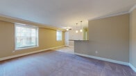 This single-floor residence offers a thoughtfully designed layout that balances comfort and functionality throughout. The open-concept living and dining area is finished with plush carpeting, crown molding, and warm neutral-toned walls, creating an inviting atmosphere. Multiple windows fitted with horizontal blinds allow generous natural light to fill the space. A ceiling fan adds practicality, while pendant lighting above the kitchen bar counter provides a stylish focal point.

The kitchen is well-equipped with rich wood cabinetry, granite countertops, a decorative tile backsplash, and a full suite of stainless steel appliances including a range, over-the-range microwave, refrigerator, and dishwasher. Light tile flooring extends throughout the kitchen area.

The bedrooms are generously sized, each featuring soft carpeting, neutral walls, and windows that bring in natural light. One bedroom is outfitted with mirrored sliding closet doors offering ample storage, while another includes direct access to a hallway with additional storage.

The primary bathroom features a granite-topped vanity with wood cabinetry, a large mirror, and a glass-enclosed tiled shower. A secondary bathroom offers a full tub-shower combination with clean white tile surround and tile flooring, rounding out this comfortable and well-maintained residence.
