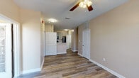 Located at 2200 Bellamy Dr in Greenville, NC, this single-floor unit offers a well-designed, functional layout throughout. The open living area is finished with durable wood-look flooring and warm neutral-toned walls, creating a bright and welcoming atmosphere. Ceiling fans are present throughout the space, providing both comfort and light. Natural light filters in through multiple windows fitted with horizontal blinds, adding to the airy feel of the interior.

The kitchen is efficiently arranged and features gray shaker-style cabinetry, light marble-look countertops, and a full suite of black appliances including an electric range, over-the-range microwave, and refrigerator. A peninsula-style counter provides a natural transition between the kitchen and the living area.

The bedrooms are comfortably sized, each with wood-look flooring, ceiling fans, and windows that bring in natural light. The bathroom is finished with matching gray cabinetry, a single vanity with a white countertop, a wall-mounted mirror with overhead lighting, and a walk-in shower equipped with grab bars for added accessibility. Wood-look flooring continues throughout the bathroom as well.

A dedicated laundry area houses a full-size washer unit with overhead wire shelving, adding a convenient and practical element to the space. Textured ceilings complete the interior throughout.
