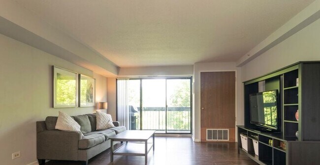 Living room with brand new heat/ac unit. Balcony overlooks golf course - 1800 Huntington Blvd