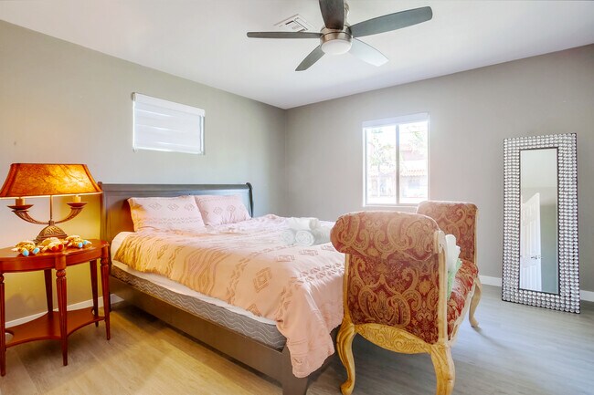 Feel like royalty in the master bedroom w/ a luxe king bed & a full-length vanity mirror - 4258 Feather Ave