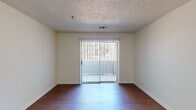 This well-appointed 2-bedroom, 2-bathroom residence in Memphis, TN is laid out across a single floor, offering a functional and comfortable living arrangement. The main living area features warm wood-style flooring and a textured ceiling, creating a cozy atmosphere. A sliding glass door opens to a private balcony, allowing natural light to fill the space and providing pleasant outdoor views. An adjacent dining area connects seamlessly to the kitchen via a convenient pass-through window, enhancing the open feel between the spaces. The kitchen is equipped with white cabinetry, ample counter space, and a full-size refrigerator. Both bedrooms are carpeted for comfort and feature natural light from large windows. The primary bedroom includes closet storage, while an additional door provides further organizational space. Each of the two full bathrooms is appointed with a tub-shower combination, a vanity with mirror, and wood-style flooring, maintaining a consistent and clean aesthetic throughout. The neutral color palette across all rooms lends a bright, move-in-ready feel to the entire residence, making it a practical and welcoming home in Memphis.