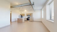 Located at 547 River St in Troy, NY, this thoughtfully designed two-bedroom, one-bathroom unit offers a contemporary living experience across a single floor. The open-concept kitchen and living area immediately impresses with its industrial-modern character — exposed silver ductwork runs prominently overhead, complementing light wood cabinetry, white quartz countertops, a central island, and a full suite of stainless steel appliances including a refrigerator, electric range, microwave, and dishwasher. Pendant lighting adds warmth to the kitchen space, while large windows bring in natural light.

The two bedrooms are well-proportioned and carpeted for comfort, each featuring closet access and neutral tones that create a calm, versatile atmosphere. One room showcases a painted brick accent wall, a nod to the building's character. The bathroom is clean and modern, with a wood-toned vanity and white countertop. Additional highlights include a dedicated laundry area, a den for flexible use, and four closets offering generous storage. A bright, clean hallway connects all rooms seamlessly. The overall aesthetic is fresh and modern with industrial touches that give the space a distinct urban character.