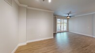 Located at 7084 Friars Road in San Diego, Unit #118 is a single-floor residence designed with a clean, contemporary aesthetic throughout. The living area is a standout space, featuring warm wood-style flooring, crown molding, and a ceiling fan centered beneath a smooth ceiling. French doors flood the room with natural light and provide direct access to a private balcony, enhancing the open, airy feel of the space.

The kitchen is well-appointed and open to the living area, centered around a large island with a granite countertop and an undermount sink, illuminated by pendant lighting overhead. White shaker-style cabinetry extends to the ceiling, offering generous storage, while stainless steel appliances—including a refrigerator, range, and microwave—complete the modern setup.

The bathroom features white cabinetry with granite countertops, a large mirror, and wood-style flooring consistent with the rest of the unit. A second bathroom includes a vanity with matching finishes, a shower, and accessibility-friendly features such as grab bars. The bedroom is carpeted in a neutral tone, providing a comfortable and quiet retreat. Throughout the unit, a neutral color palette and consistent finishes create a cohesive, move-in-ready environment.