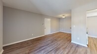 Located at 905 Bryan Pl in Garner, NC, this one-bedroom, one-bathroom unit offers a well-organized single-floor layout designed for comfortable everyday living. Wood-style plank flooring runs throughout, complementing neutral gray walls and white trim for a clean, modern aesthetic. Textured ceilings add architectural character across the space.

The open living and dining area is a standout feature, boasting built-in wall shelving for display or storage and a sliding glass door that fills the room with natural light while providing direct access to a private balcony with outdoor views. A second set of built-in shelves adds additional functional charm near the entryway.

The galley-style kitchen is efficiently designed with white cabinetry, subway tile backsplash, dark countertops, a double-basin sink, dishwasher, electric range, and a refrigerator. A dedicated pantry provides additional storage, and the kitchen opens conveniently toward the in-unit laundry area.

The bedroom is a comfortable retreat featuring a window with natural light, hardwood-style flooring, and access to ample closet space. The full bathroom includes a wide vanity with under-sink cabinetry, a large mirror, gray countertop, and a tub/shower combination. A hallway connects all areas seamlessly, rounding out this practical and move-in-ready home.