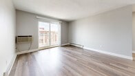 Located at 141 Sea St in Quincy, MA, this 2-bedroom, 1-bathroom unit offers a well-designed single-floor layout with a clean, modern aesthetic throughout. Light wood-tone flooring runs continuously across the living spaces, complementing neutral gray walls and crisp white trim for a bright, cohesive look.

The combined kitchen and living area serves as the heart of the unit. The kitchen is outfitted with white shaker cabinetry, dark granite-style countertops, a white subway tile backsplash, and a full suite of stainless steel appliances including a range, dishwasher, refrigerator, and a stainless sink. The living room receives abundant natural light and opens directly onto a private balcony through sliding glass doors, providing pleasant outdoor views.

The spacious primary bedroom features two windows that fill the room with natural light, baseboard heating, and generous proportions. The second bedroom also offers good natural light, baseboard heating, and a closet. Both bedrooms maintain the same warm wood flooring and neutral palette found throughout the unit.

The bathroom is finished with a clean, all-white design, featuring a full soaking tub with a tiled surround and a vanity with sink. Baseboard heating is present throughout, ensuring year-round comfort in this move-in-ready Quincy residence.