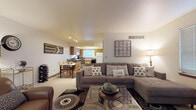 Located at W158N8398 Steven Mack Dr in Menomonee Falls, Wisconsin, this two-floor residence offers a functional and comfortable layout designed for everyday living. The main level showcases an open-concept design where the living room, dining area, and kitchen flow seamlessly together. The living room is carpeted and well-lit, providing an inviting space for relaxation. The kitchen features warm wood cabinetry, granite-style countertops, a peninsula with bar seating, a full suite of appliances including a dishwasher and refrigerator, and a window that brings in natural light with views of the surrounding neighborhood. Light hardwood-style flooring runs through the kitchen, adding a clean, modern contrast. A dining area adjacent to the kitchen comfortably accommodates a full table setting. The upper level includes a carpeted bedroom with ample natural light from horizontal-blind windows, and a dedicated home office space with built-in shelving and a bright window outlook. Two bathrooms serve the residence — one featuring a walk-in glass shower and wood-toned vanity, and another with a full tub/shower combination and an extended vanity with generous counter space. Throughout, the home maintains a neutral color palette and practical finishes that create a warm, livable atmosphere.
