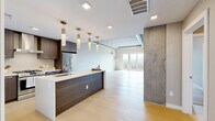 Located at 1515 Julian St in Denver's vibrant 80204 neighborhood, this thoughtfully designed one-bedroom, one-bathroom unit blends industrial character with contemporary elegance. The open-concept kitchen and living area serves as the heart of the home, showcasing light hardwood floors, exposed concrete ceilings with visible ductwork, and dramatic exposed concrete columns that lend an urban loft aesthetic. The kitchen is equipped with stainless steel appliances, dark wood cabinetry, a large center island with a white quartz countertop, an undermount sink, and a series of stylish brass pendant lights that add warmth and sophistication. The spacious living area benefits from floor-to-ceiling windows and sliding glass door access to a private balcony, inviting abundant natural light and open city views. The generously sized primary bedroom continues the loft-inspired design with exposed concrete ceilings, large windows overlooking the Denver skyline, and direct access to two well-appointed closets. The full bathroom features a freestanding soaking tub, a glass-enclosed walk-in shower, dual floating vanities with dark wood cabinetry and illuminated mirrors, and large-format tile flooring, creating a refined, spa-like retreat.